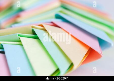 Origami background, close up photo with selective soft focus. Abstract parametric structure made of colorful paper sheets Stock Photo