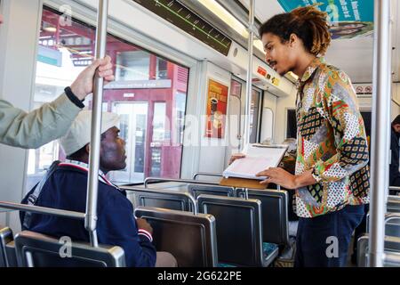 Los Angeles California,LA County Metro Rail,rail,subway,train,mass transit,train,interior inside,sitting,seat,commuter,Black man men male,standing,sur Stock Photo