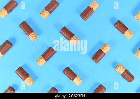 Chocolate glazed waver rolls sweets arranged on blue background Stock Photo