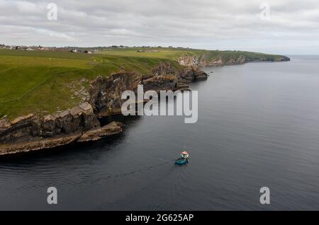 Aerial view of fishing boat leaving Lybster Harbour, Caithness, Scotland. Stock Photo