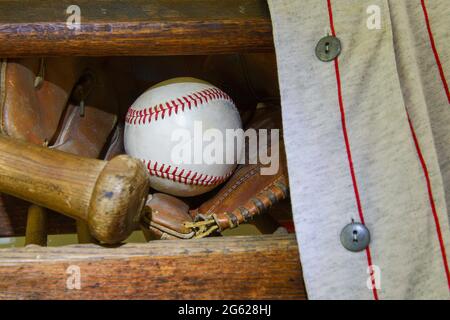 Still of a baseball, bat, glove and player's shirt in gray and red. Stock Photo