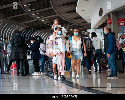 Medellin, Antioquia, Colombia - May 17 2021: Latin Family with Mask Walks with their Bags at the Jose Maria Cordova Airport Terminal Stock Photo