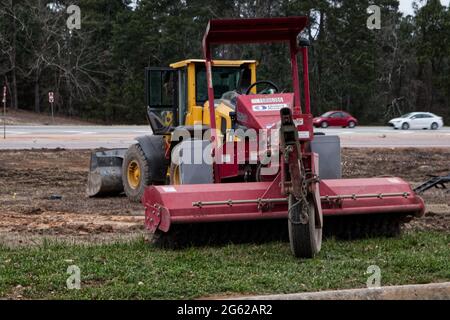 Augusta, Ga USA - 03 06 21:  Yellow dozer and red street cleaner at a construction site - Hwy 1 Stock Photo