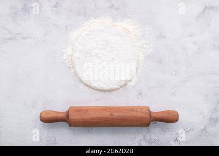 Fresh homemade yeast dough resting on whote concreate background flat lay with rolling pin. Stock Photo
