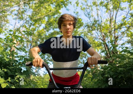 portrait of cheereful young man on the bike, riding in the city street Stock Photo
