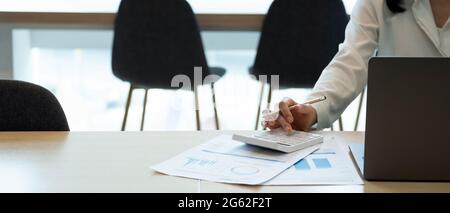 Close up businesswoman using calculator working at office with reports document financial. accounting finance concept Stock Photo