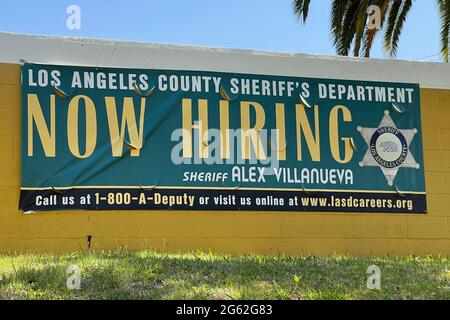 A Now Hiring sign at the East Los Angeles Sheriff's Department office, Thursday, July 1, 2021, in Los Angeles. Stock Photo