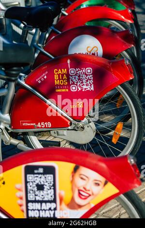 Seville Spain July 01, 2021 Accessible bicycles to hire for short periods of time, usually for a few hours parked in the street and part of the public Stock Photo