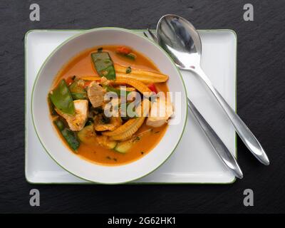 Spicy Red Thai Curry with Chicken and Vegetables in a Bowl, Top View Stock Photo