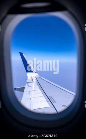 View of an Airbus 320 left-wing seen through the airplane window. Stock Photo