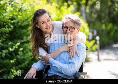 Elderly Senior Patient Care Outside. Older Man In Wheelchair Stock Photo