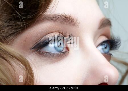 Closeup macro shot of blue human female eyes. Woman with natural vogue face beauty makeup. Stock Photo