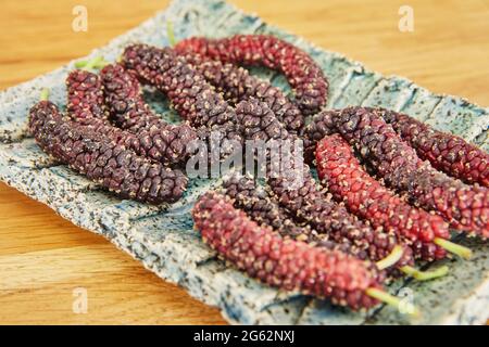 Afghan mulberry black and red lying on plate, close-up Stock Photo