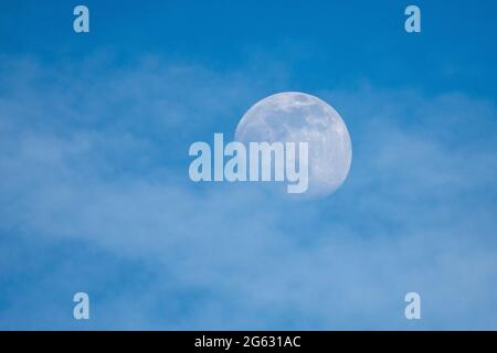 almost full moon over blue sky Stock Photo