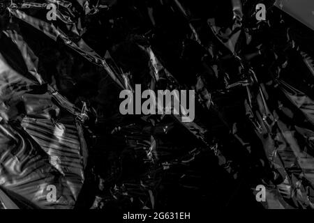 Black crumpled wrinkled metal aluminum foil. Grunge abstract detailed dark background Stock Photo
