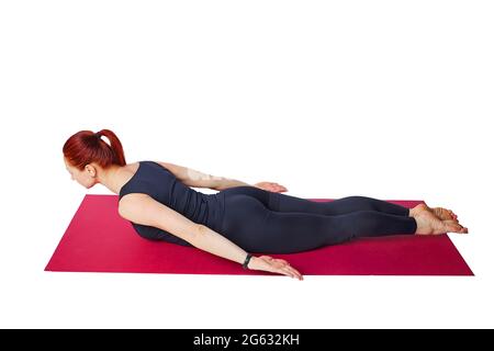 Pilates or yoga. A slender athletic girl performs an exercise to strengthen the back muscles. Wellness exercises and immersive fitness. Isolated on a white background. Visual aid. Mind and body Stock Photo