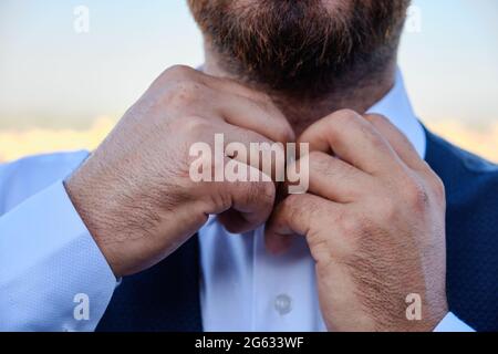 Man buttons his white shirt up Stock Photo