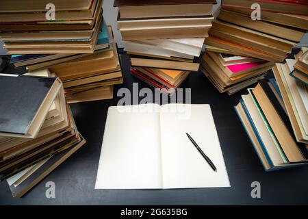 Big stack of books on the table. Studying before the exam. Pile of vintage books. Concept of education and studying Stock Photo