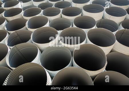 Downpipe warehouse. Steel pipes, parts for the construction of a roof drainage system in a warehouse. Stack of stainless steel pipes. Stock Photo