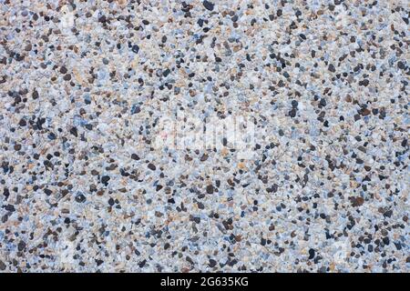 Abstract background decorative mosaic plaster. Stucco backdrop with rocks crumbs. Pebble plaster finishing - surface coating made of small stones Stock Photo