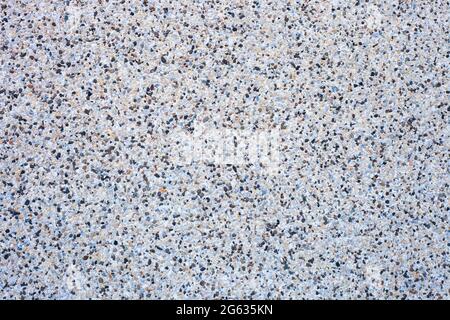 Abstract background decorative mosaic plaster. Stucco backdrop with rocks crumbs. Pebble plaster finishing - surface coating made of small stones Stock Photo
