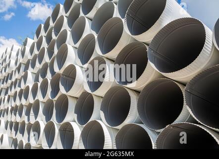 Downpipe warehouse. Steel pipes, parts for the construction of a roof drainage system in a warehouse. Stack of stainless steel pipes. Stock Photo