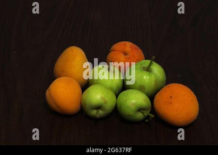 Apricots and apples on wooden table Stock Photo