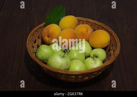 Apricots and apples on wooden table Stock Photo