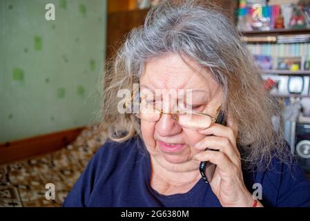 Serious Elderly Jewish Woman Talking on the Phone at Home Stock Photo