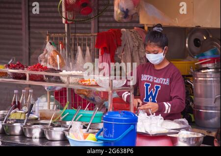 Female Cambodian tropical fruit / dessert vendor wearing a protective face mask / covering during the coronavirus pandemic. The Kandal Market, Phnom Penh, Cambodia. March 25th, 2020. © Kraig Lieb Stock Photo