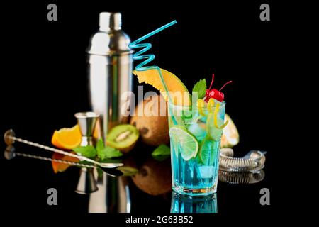 Blue Lagoon cocktail with a slice of melon and cherry isolated on white