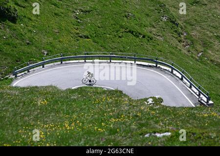 Road cyclists on the south side of the Splügen Pass. Stock Photo