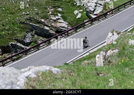 Road cyclists on the south side of the Splügen Pass. Stock Photo