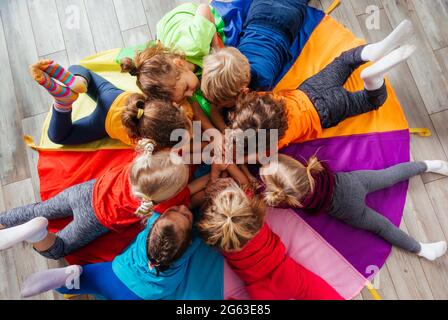 Cheerful children playing team building games on a floor Stock Photo