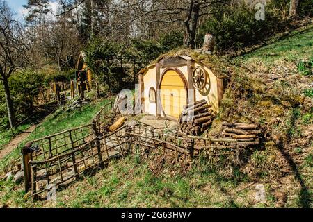 Hobbit house in Czech Hobbiton with three Hobbit holes and cute yellow doors.Fairy tale home in garden.Magic small village from fantasy movie located