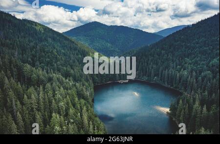 Lake Synevir framed by pine wood in Carpathian Mountains Stock Photo