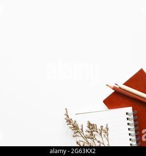 Notebook, colored pencil, dry flowers on white background. flat lay, top view, copy space. Work and study place Stock Photo