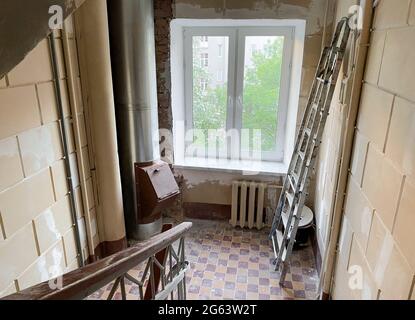 Repair works, renovation of the entrance of an apartment building. Inside. Top view of the stairwell, a new window and a garbage chute. The walls have Stock Photo