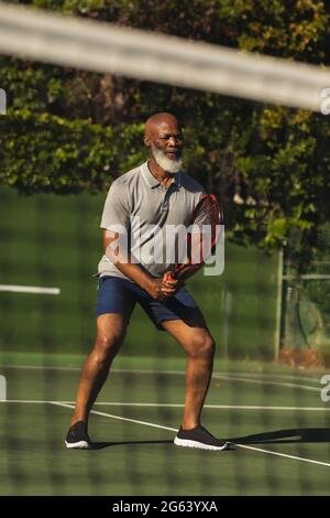 Senior african american man playing tennis on tennis court Stock Photo