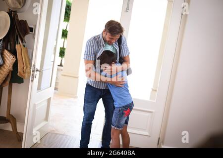 Happy caucasian father with son at home, smiling and embracing Stock Photo