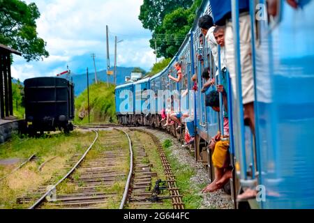 Tourists Enjoying train ride from Ella to Kandy among tea plantations in the highlands of Sri Lanka Stock Photo