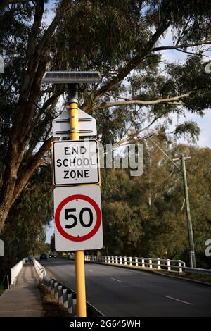 Sign indicating end of School Zone and commencement of speed limit of 50 kilometers per hour. Stock Photo