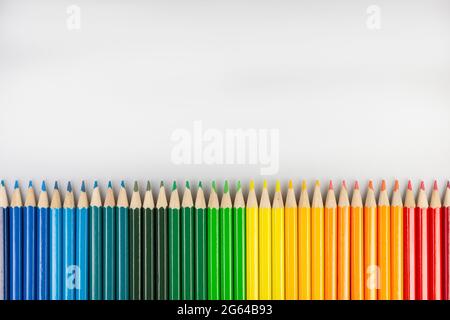 Row of cedar colored pencils on a horizontal white paper Stock Photo