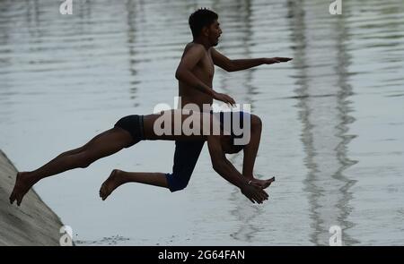 New Delhi, India. 02nd July, 2021. People jump into a canal to get some respite from scorching heat on a hot summer day in the Indian capital of New Delhi on Friday, July 2, 2021. Many parts of the country are reeling under severe heat wave. Photo by Abhishek/UPI Credit: UPI/Alamy Live News Stock Photo