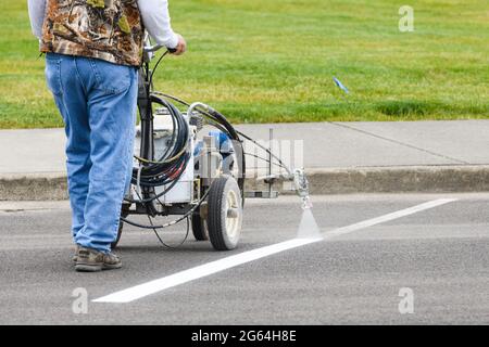 Westport, WA, USA - June 24, 2021; A machine is used to paint the white dividing line on a parking space in the Washington State town of Westport Stock Photo