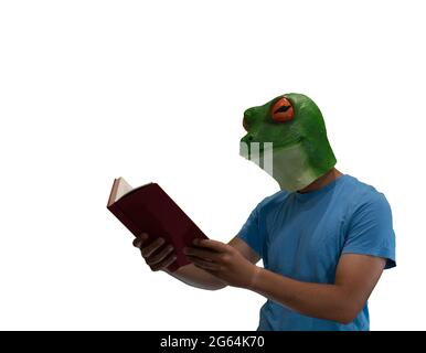 man with an animal mask of a frog on his head enjoying reading a book on a white background and copy space Stock Photo