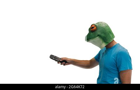 man with animal mask of a frog on his head with television remote control on white background with copy space Stock Photo
