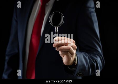 Businessman with a magnifying glass in his hand. Stock Photo