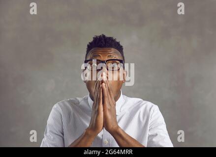 Afraid scared african american man covering mouth with hands feel horrified Stock Photo