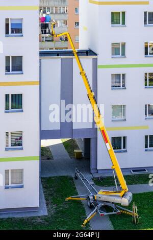 the specialist inspects the facade of the house with the help of a modern mobile self propelled hydraulic lifting platform Stock Photo